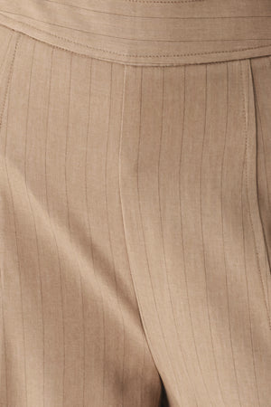 A person wearing high-waisted, wide-leg trousers in a warm taupe-brown color | FREEMARKET