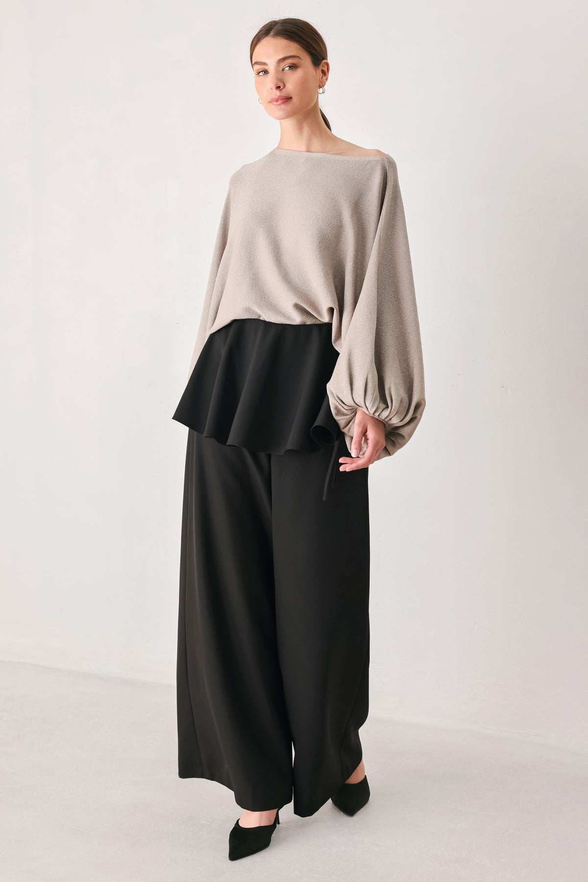 Black wide-leg pants with a dramatic layered ruffle waistband, shown on a model | FREEMARKET