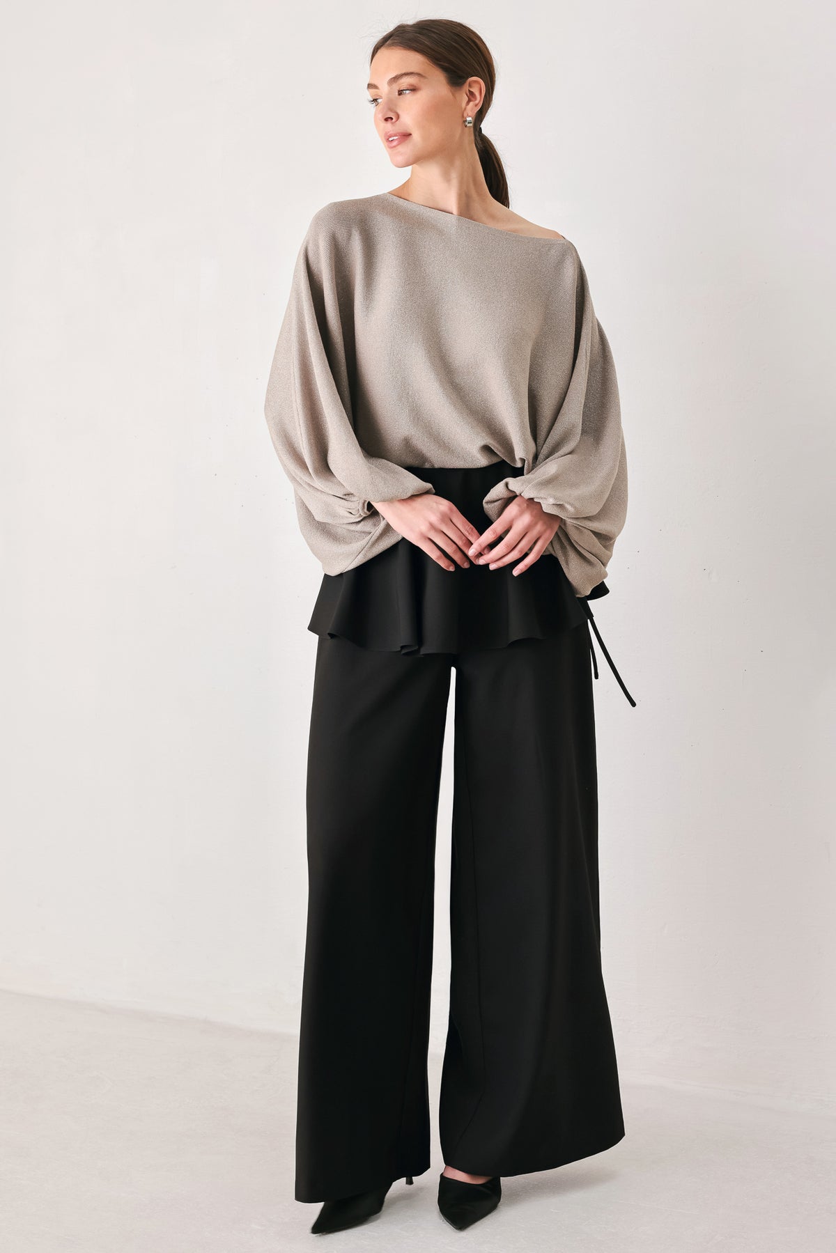 Black wide-leg pants with a dramatic layered ruffle waistband, shown on a model | FREEMARKET