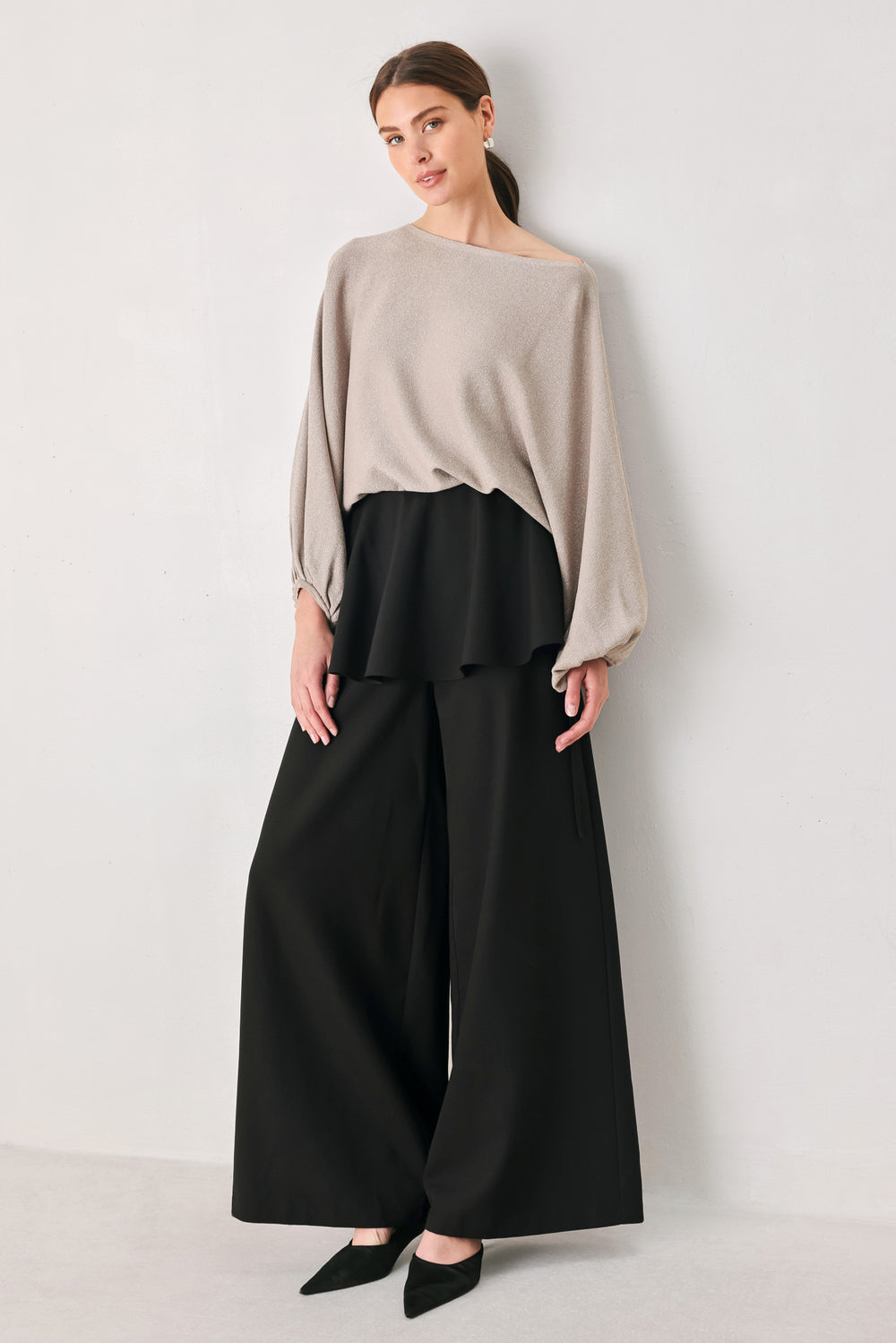 Black wide-leg pants with a dramatic layered ruffle waistband, shown on a model | FREEMARKET