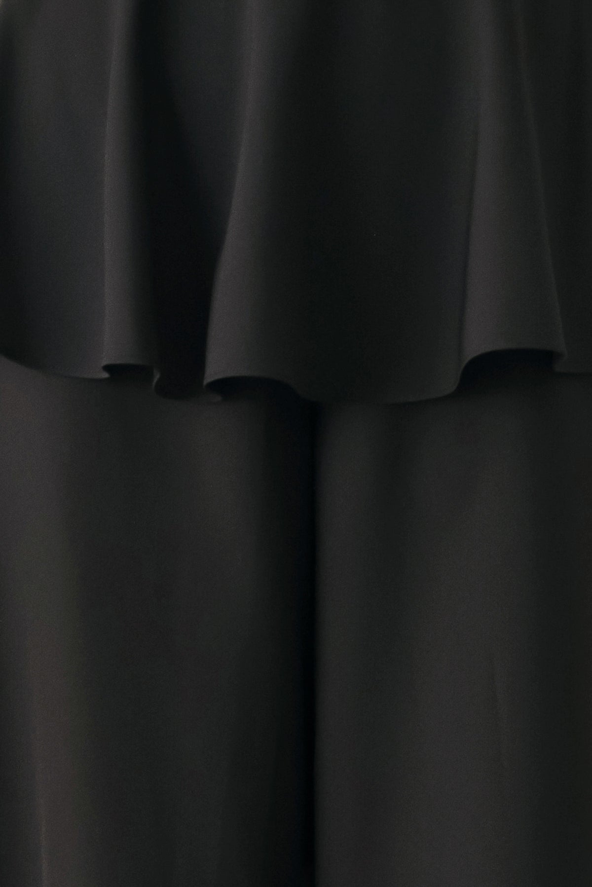 Black wide-leg pants with a dramatic layered ruffle waistband, shown on a model | FREEMARKET