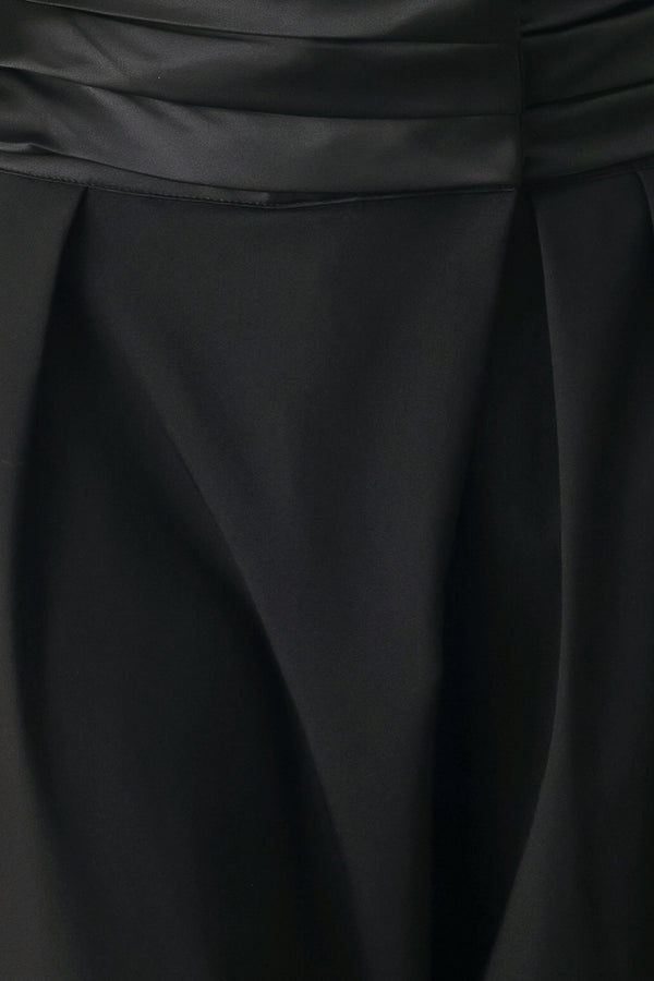 A model wearing high-waisted, wide-leg black trousers with a satin-like waistband | FREEMARKET