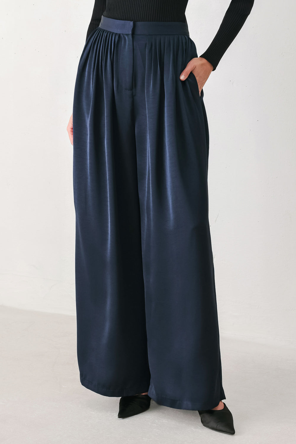 Woman wearing a navy blue satin pants with pleats | FREEMARKET
