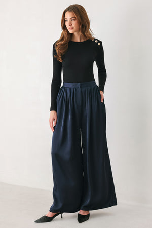 Woman wearing a navy blue satin pants with pleats | FREEMARKET
