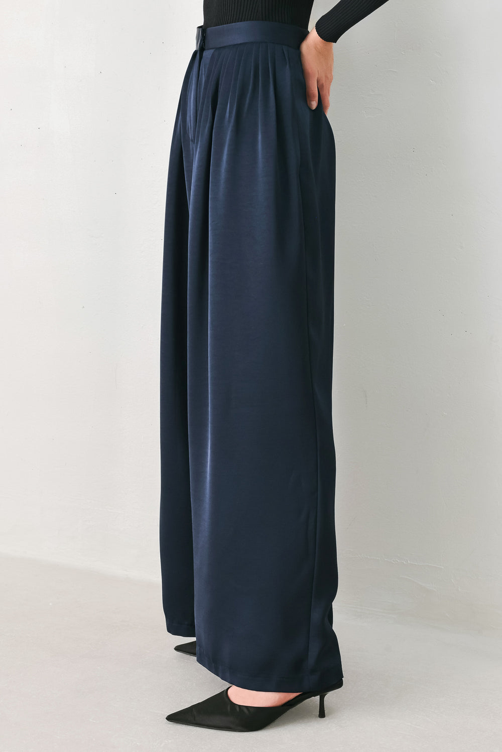 Woman wearing a navy blue satin pants with pleats | FREEMARKET