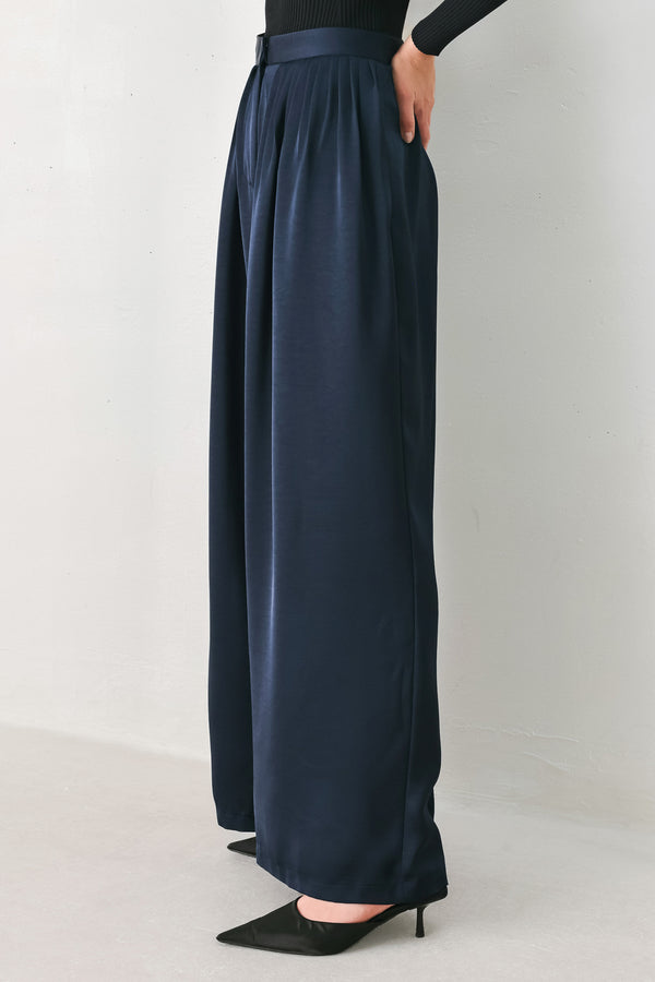 Woman wearing a navy blue satin pants with pleats | FREEMARKET