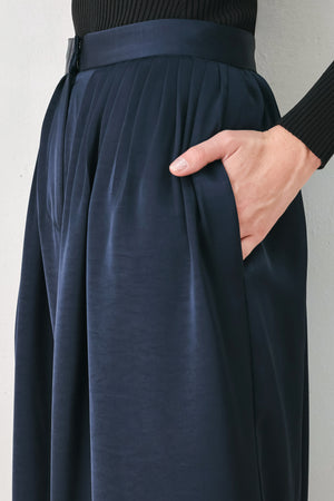 Woman wearing a navy blue satin pants with pleats | FREEMARKET