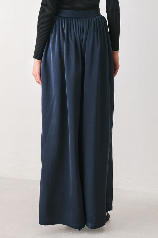 Woman wearing a navy blue satin pants with pleats | FREEMARKET