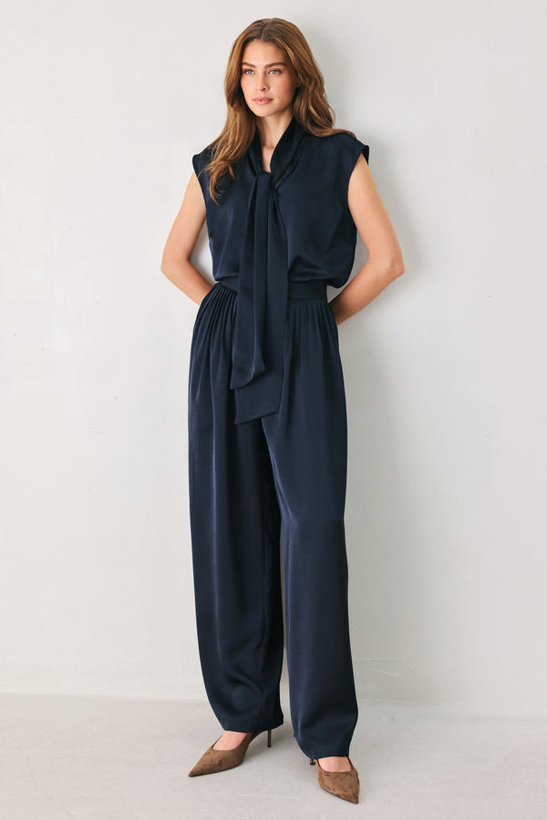 Woman wearing a navy blue satin pants with pleats | FREEMARKET