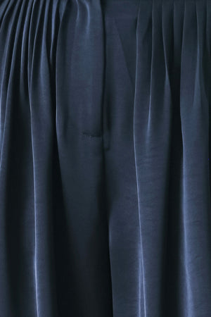 Woman wearing a navy blue satin pants with pleats | FREEMARKET