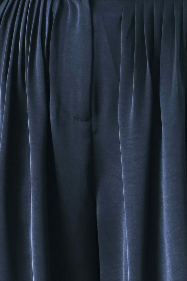 Woman wearing a navy blue satin pants with pleats | FREEMARKET