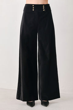 Woman wearing a pair of high waisted velvet pants and with double breasted buttons on the waistband | FREEMARKET