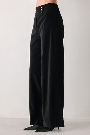 Woman wearing a pair of high waisted velvet pants and with double breasted buttons on the waistband | FREEMARKET