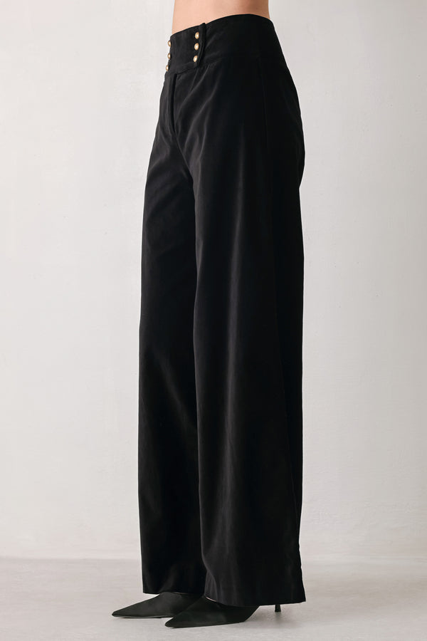 Woman wearing a pair of high waisted velvet pants and with double breasted buttons on the waistband | FREEMARKET