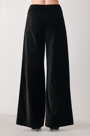Woman wearing a pair of high waisted velvet pants and with double breasted buttons on the waistband | FREEMARKET