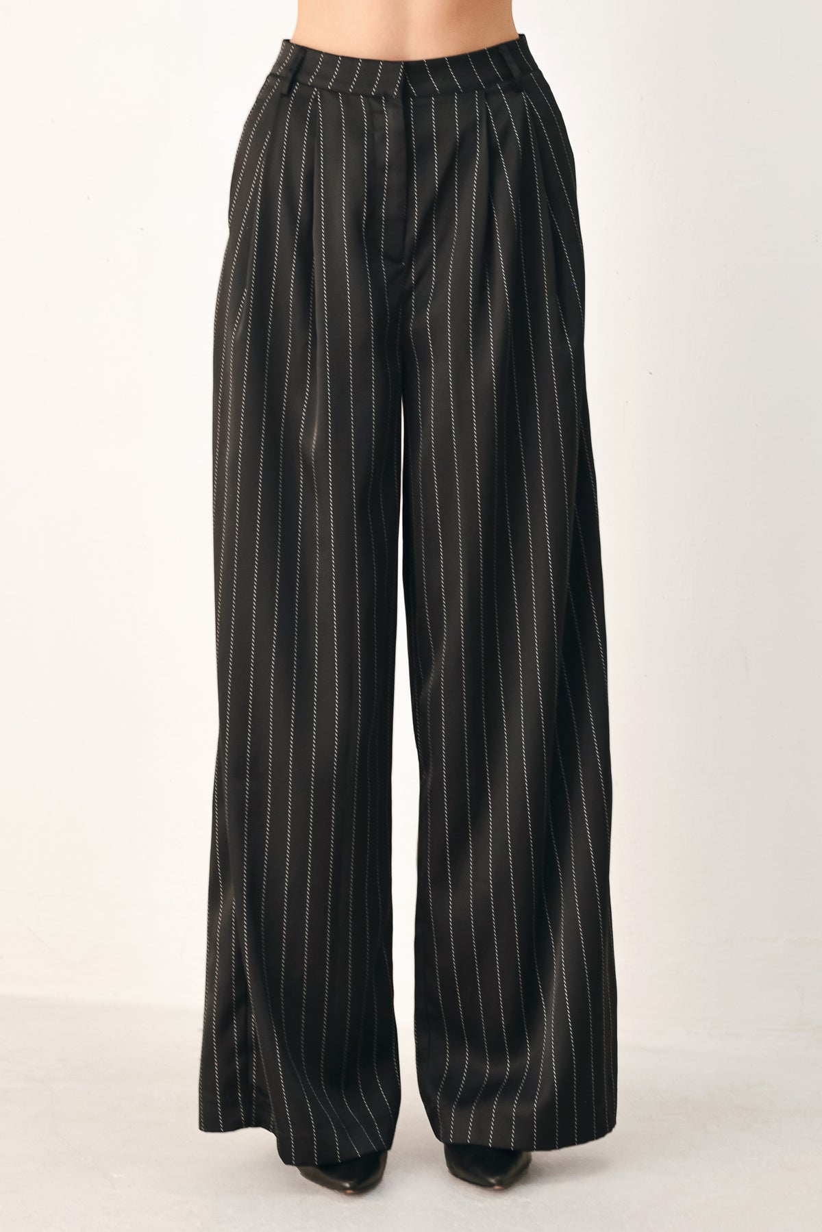 Black wide-leg trousers with thin white vertical pinstripes, shown on a model | FREEMARKET