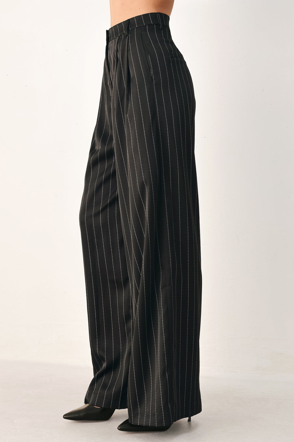 Black wide-leg trousers with thin white vertical pinstripes, shown on a model | FREEMARKET
