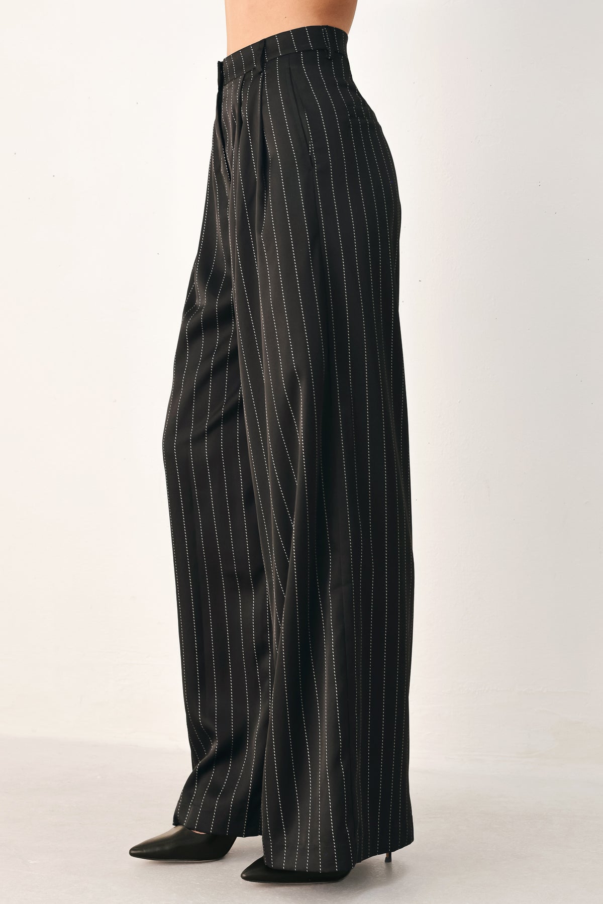 Black wide-leg trousers with thin white vertical pinstripes, shown on a model | FREEMARKET