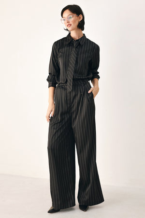 Black wide-leg trousers with thin white vertical pinstripes, shown on a model | FREEMARKET
