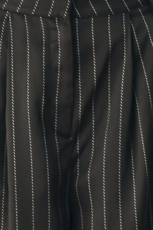 Black wide-leg trousers with thin white vertical pinstripes, shown on a model | FREEMARKET