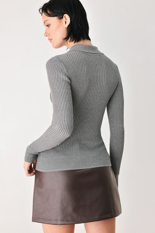 A woman wearing a gray ribbed long-sleeve polo-neck knit top | FREEMARKET