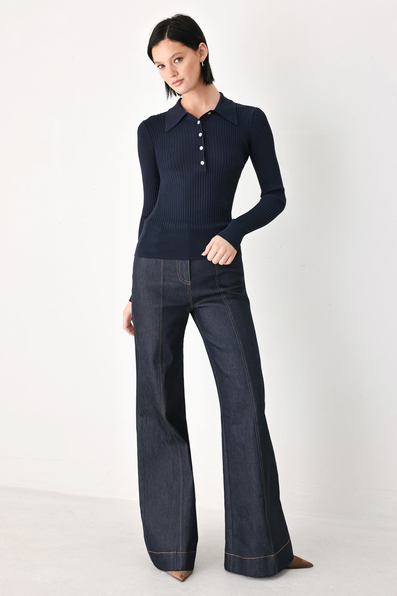 A woman wearing a navy blue ribbed long-sleeve polo-neck knit top | FREEMARKET