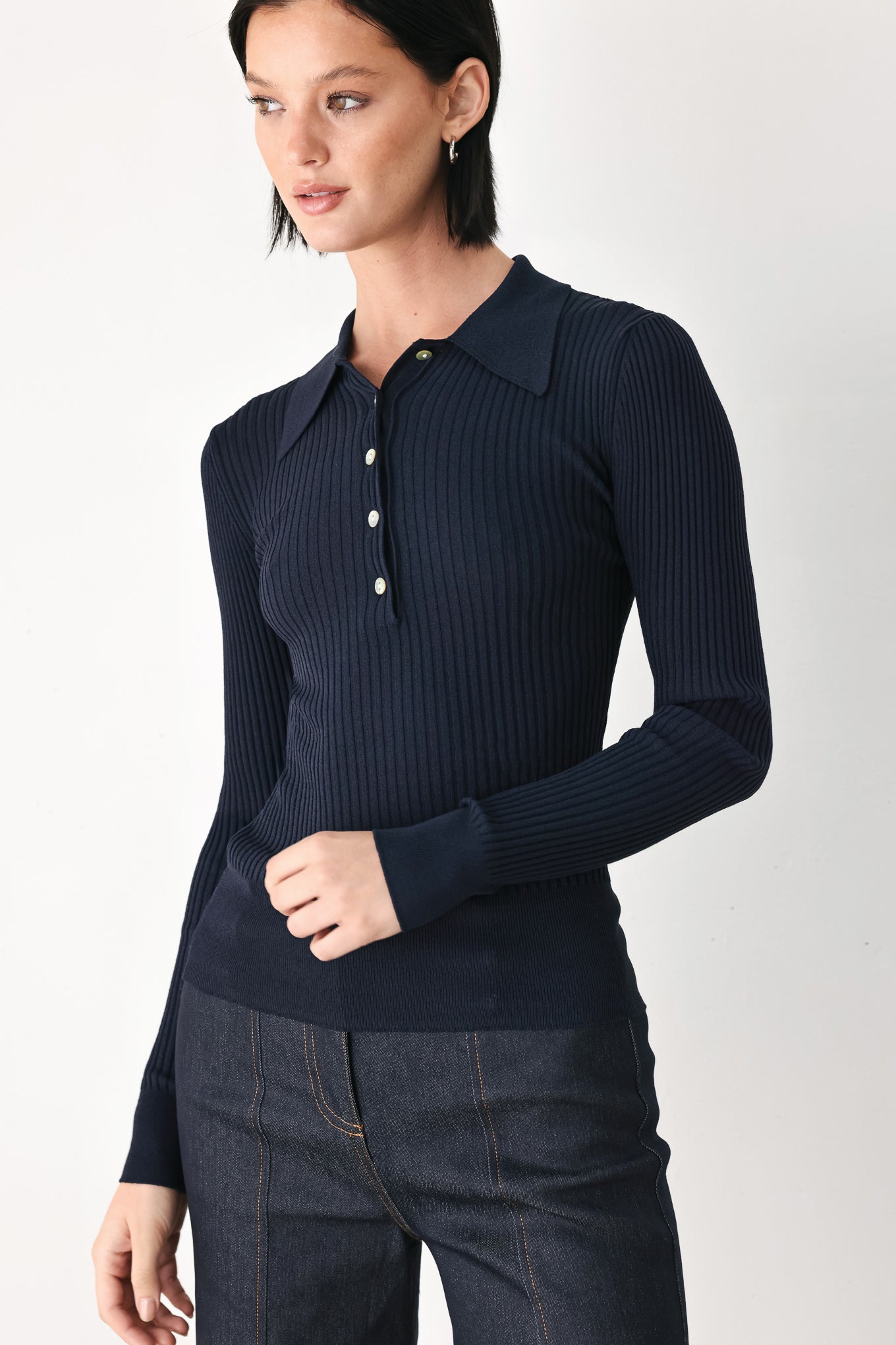 A woman wearing a navy blue ribbed long-sleeve polo-neck knit top | FREEMARKET