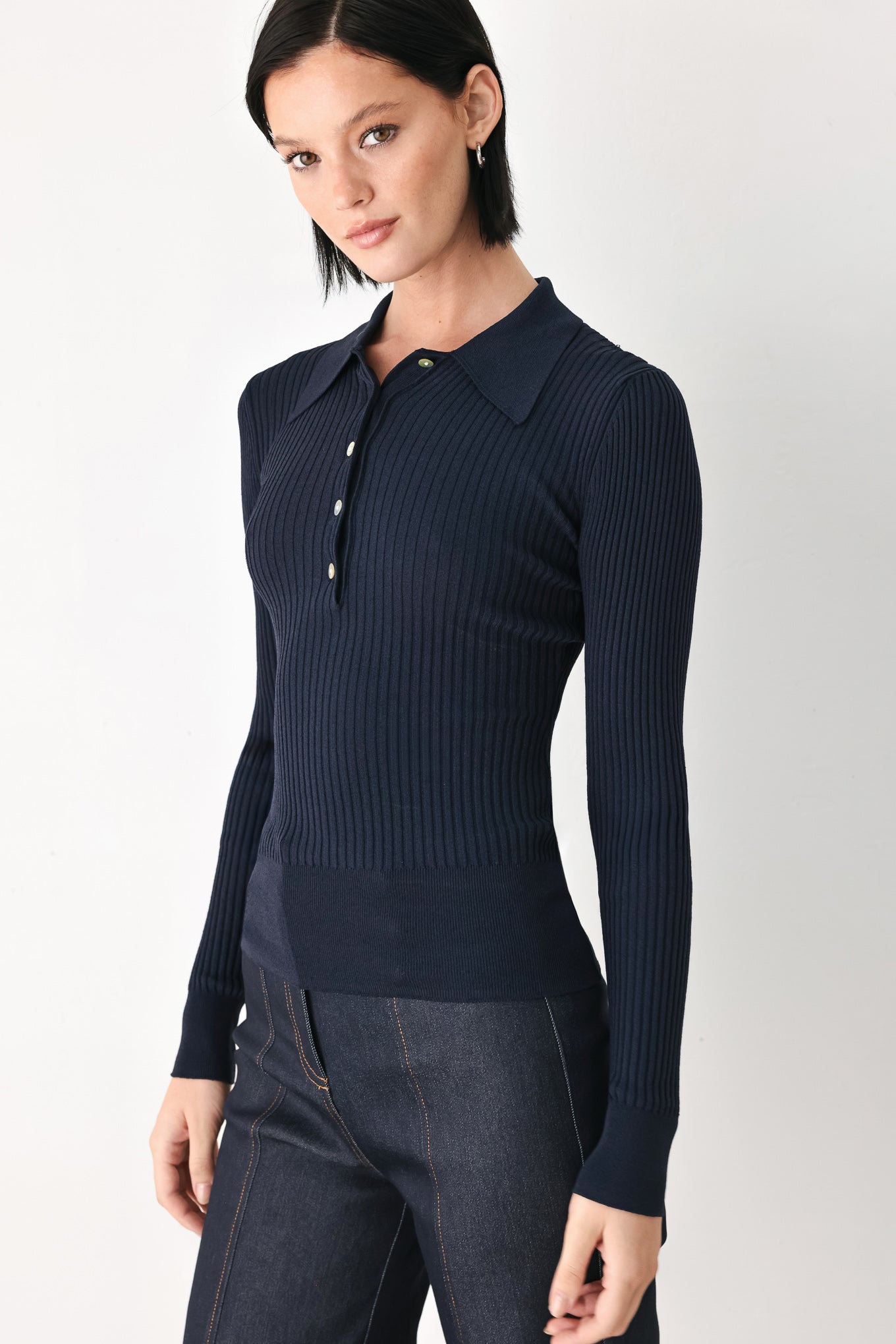 A woman wearing a navy blue ribbed long-sleeve polo-neck knit top | FREEMARKET