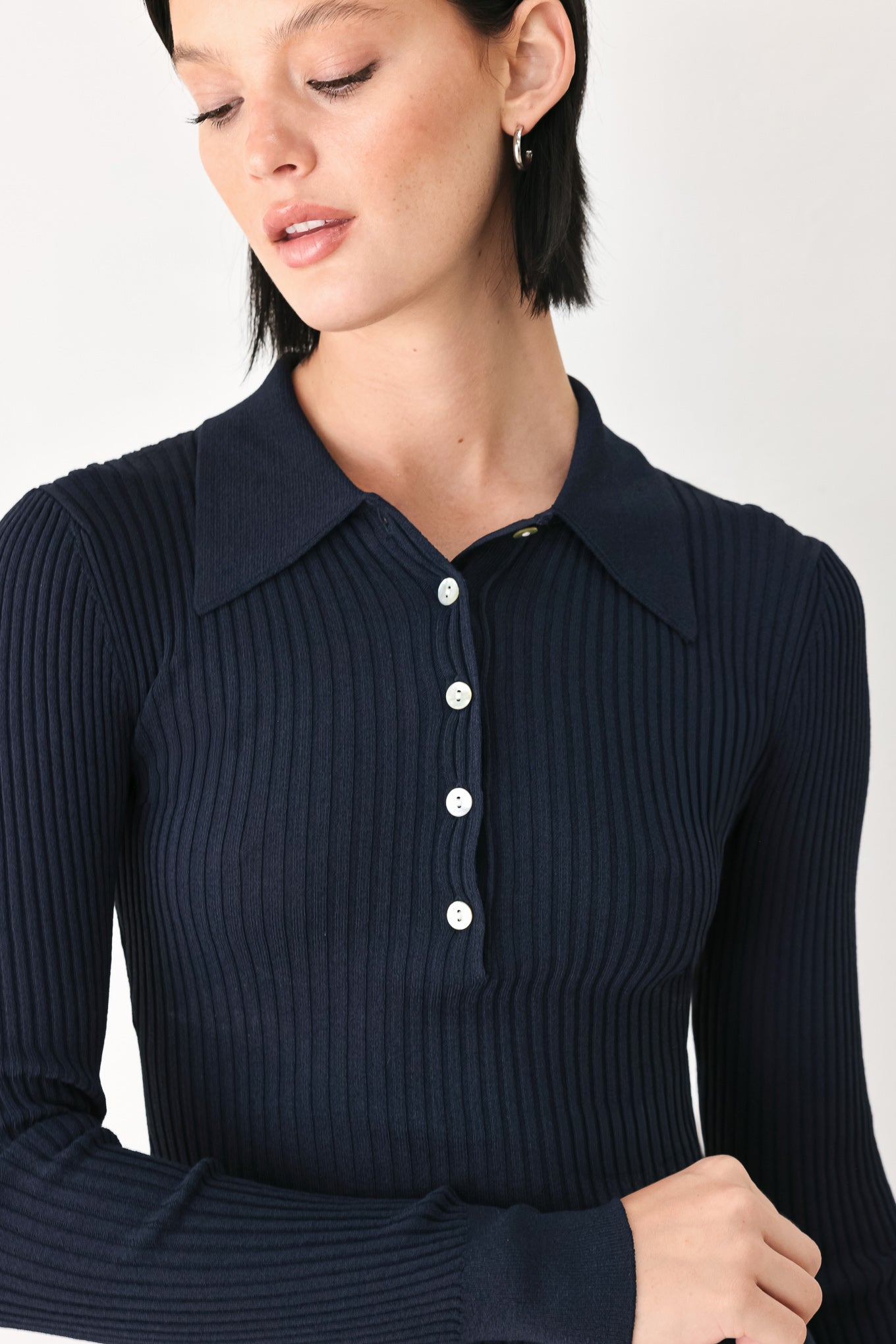 A woman wearing a navy blue ribbed long-sleeve polo-neck knit top | FREEMARKET