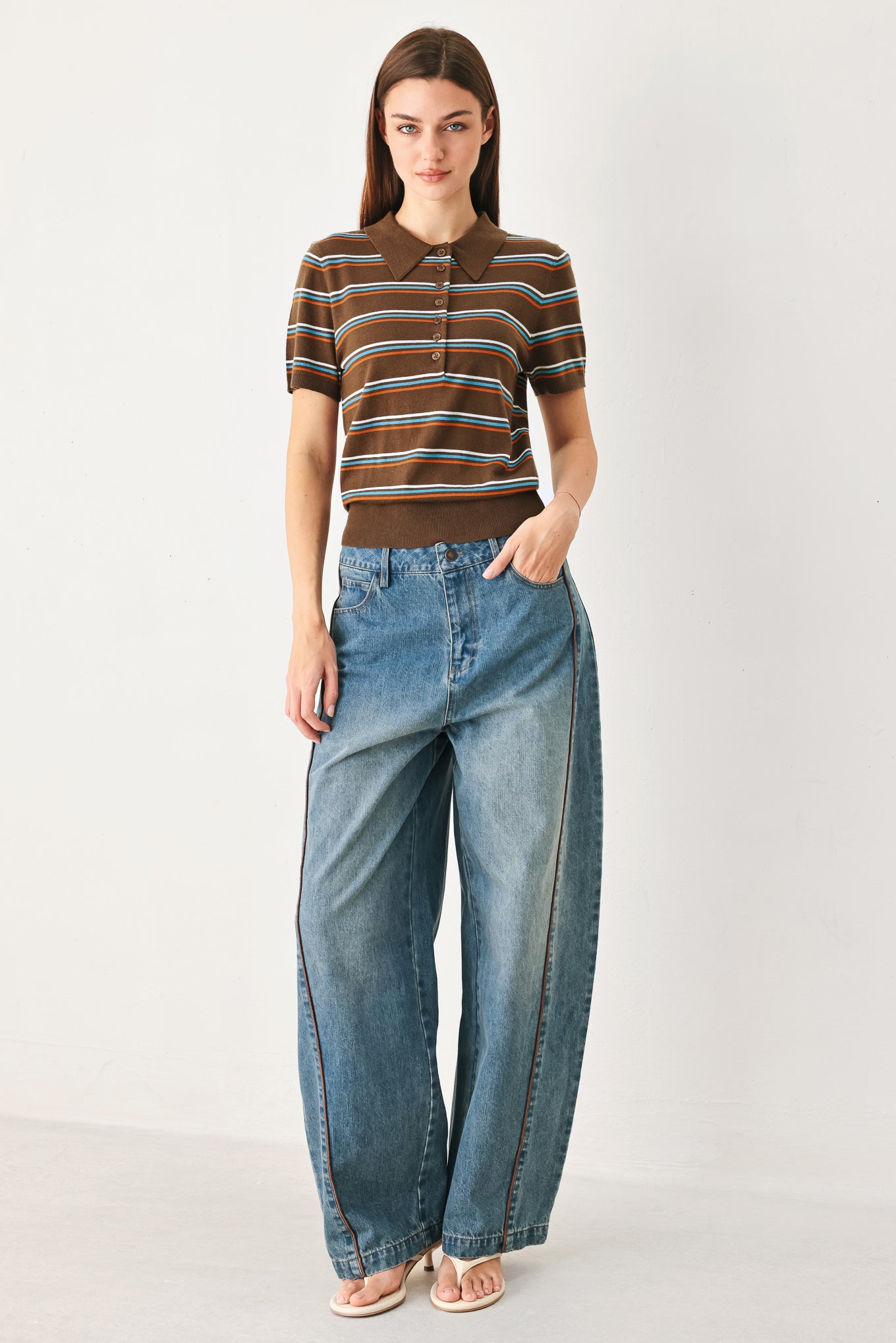 A woman wearing a brown short-sleeve knit polo shirt with horizontal stripes in blue, orange, and white | FREEMARKET