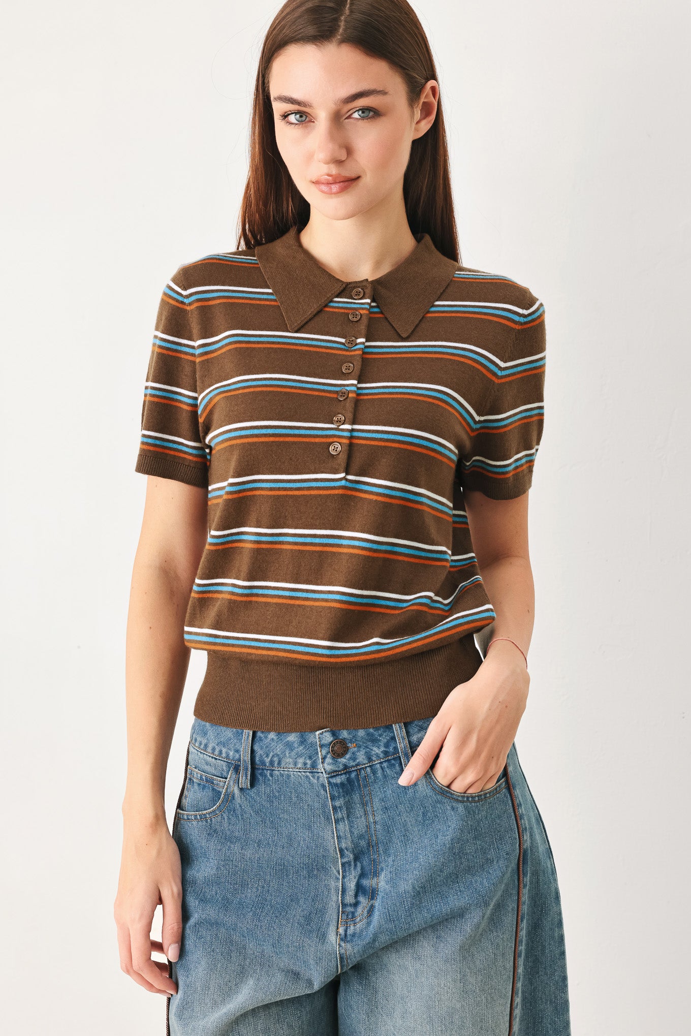 A woman wearing a brown short-sleeve knit polo shirt with horizontal stripes in blue, orange, and white | FREEMARKET
