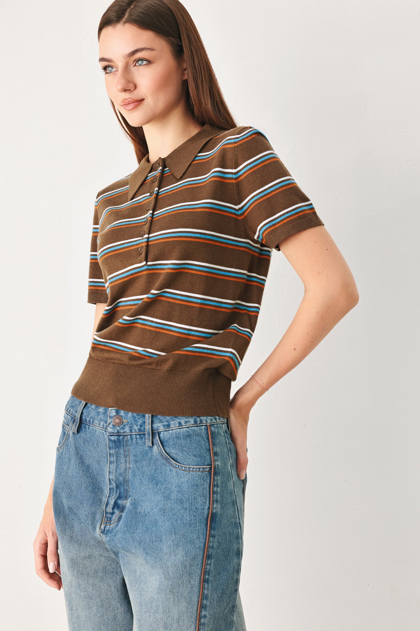 A woman wearing a brown short-sleeve knit polo shirt with horizontal stripes in blue, orange, and white | FREEMARKET