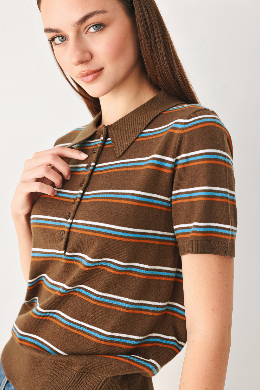 A woman wearing a brown short-sleeve polo shirt with horizontal stripes in white, blue, and orange | FREEMARKET