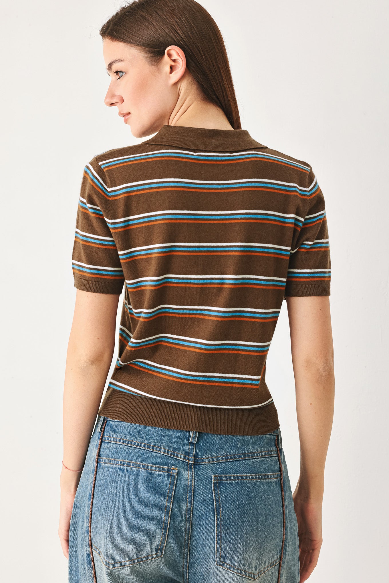 A woman wearing a brown short-sleeve knit polo shirt with horizontal stripes in blue, orange, and white | FREEMARKET