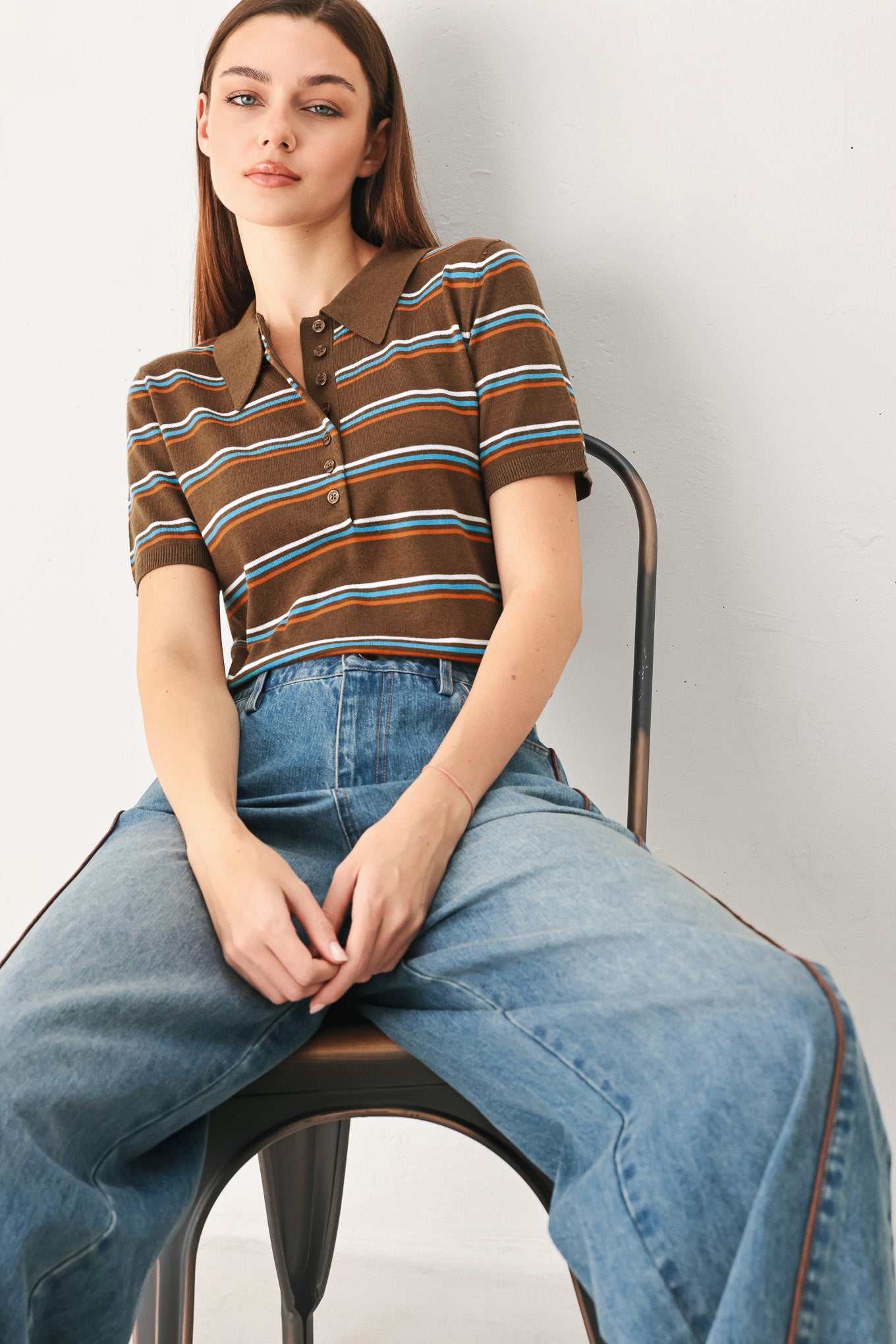 A woman wearing a brown short-sleeve knit polo shirt with horizontal stripes in blue, orange, and white | FREEMARKET