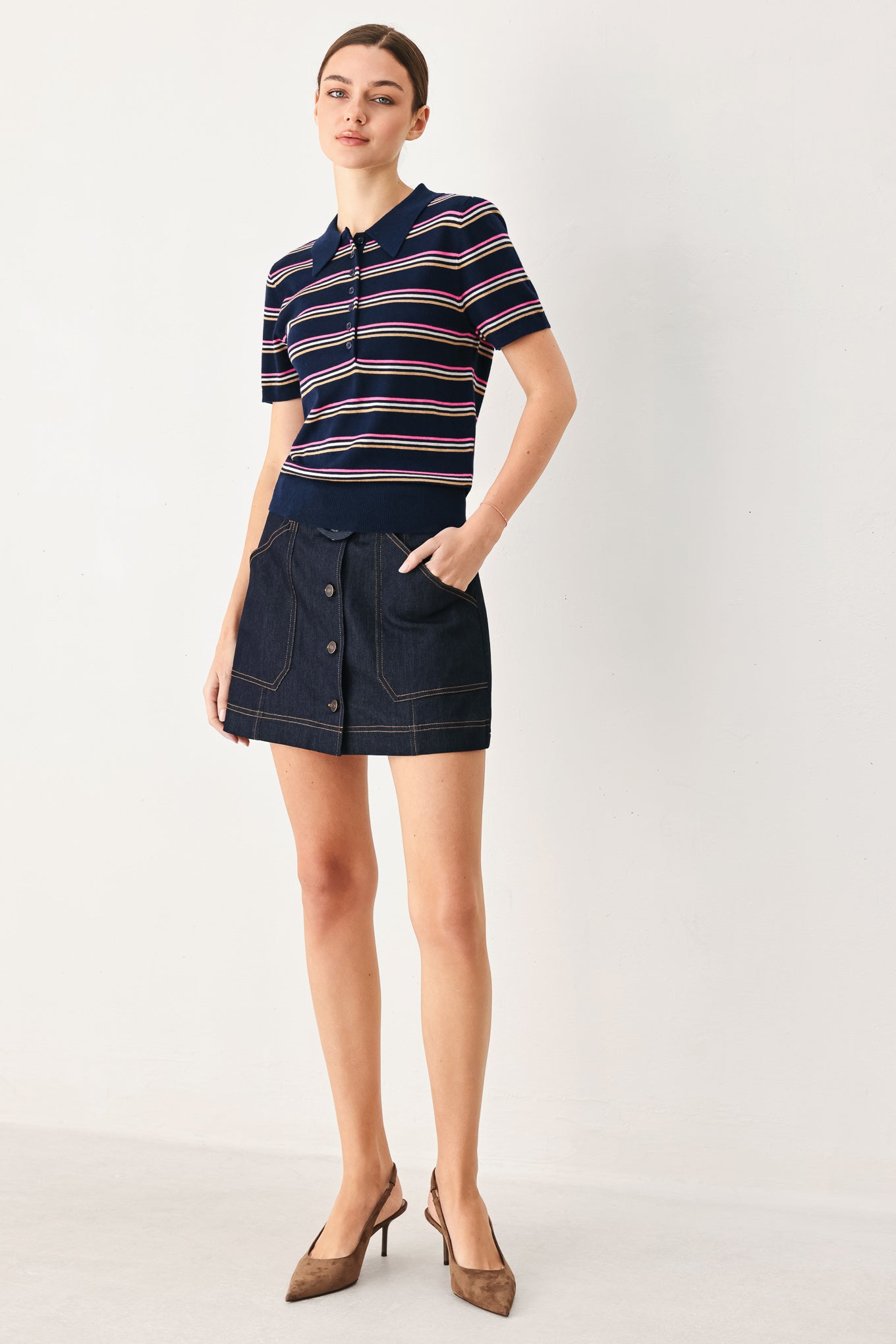 A woman wearing a navy blue short-sleeve polo shirt with thin horizontal stripes in pink, yellow, and white | FREEMARKET