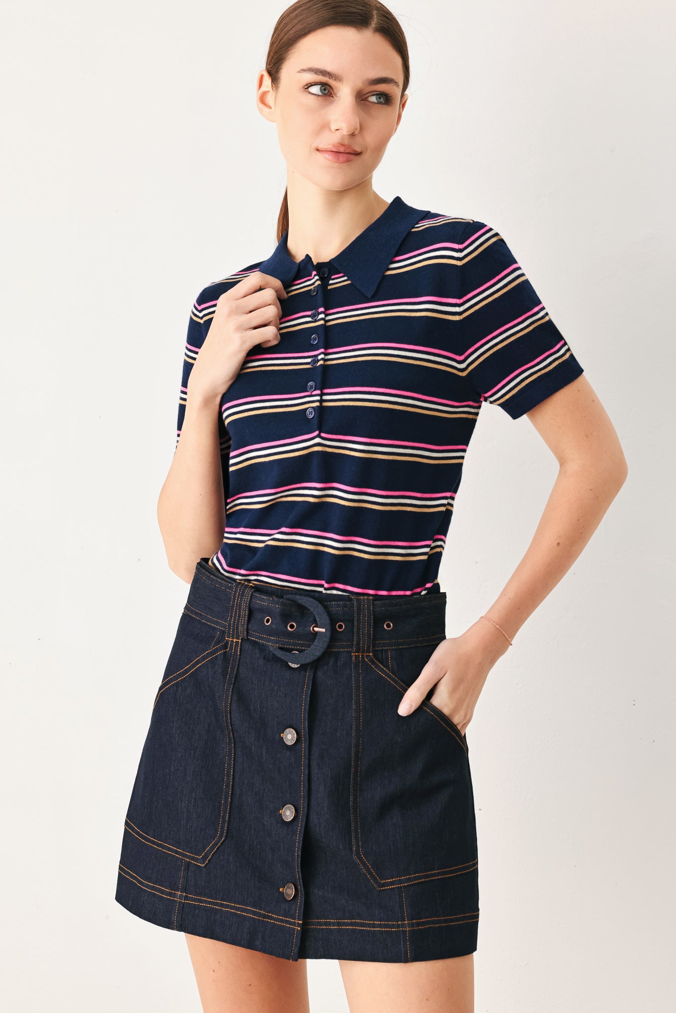 A woman wearing a navy blue short-sleeve polo shirt with thin horizontal stripes in pink, yellow, and white | FREEMARKET