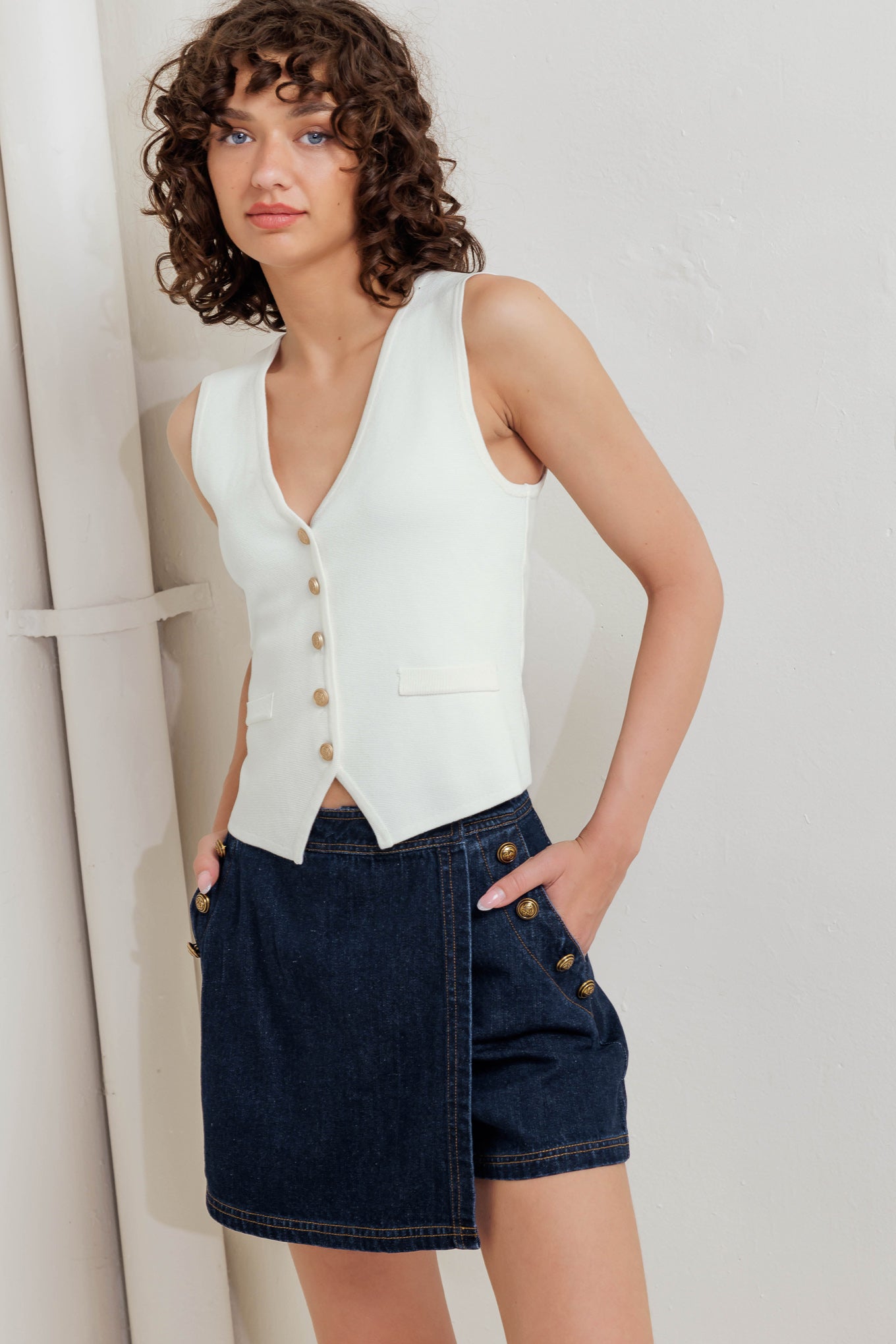 A solid white sweater vest with front button closure