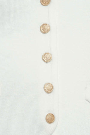 A solid white sweater vest with front button closure