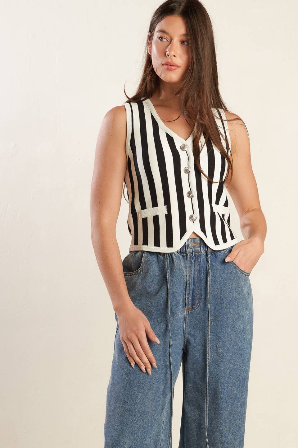 A striped white and black sweater knit vest with front button closure.