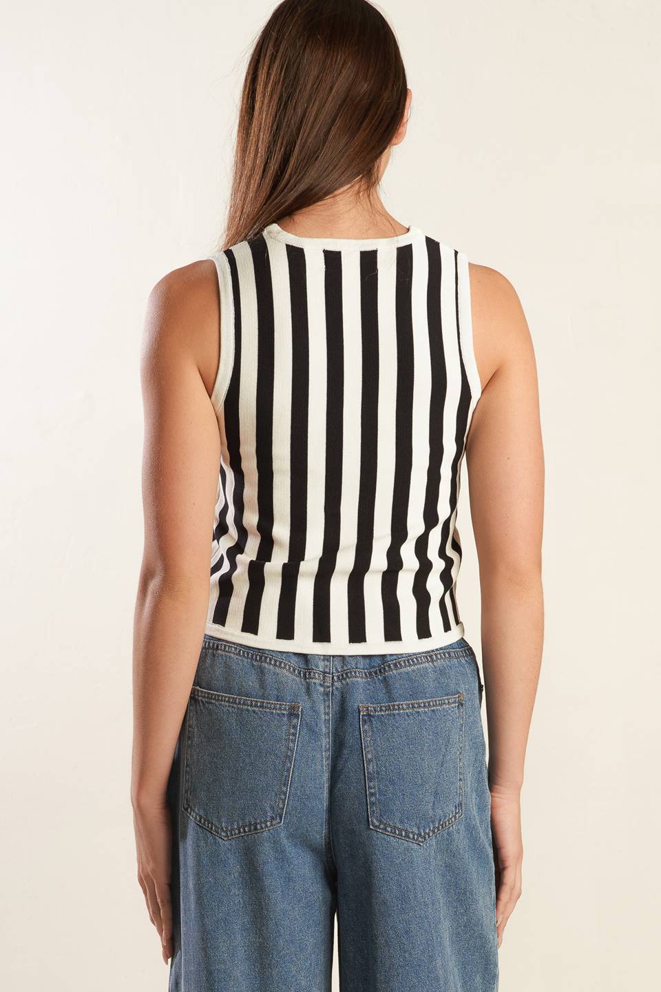 A striped white and black sweater knit vest with front button closure.