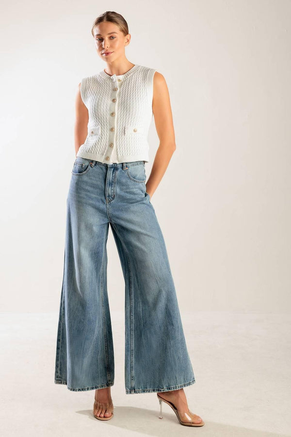 A white, sleeveless, sweater knit vest featuring round neckline and button down closure.