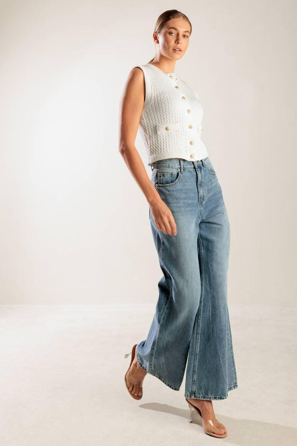 A white, sleeveless, sweater knit vest featuring round neckline and button down closure.