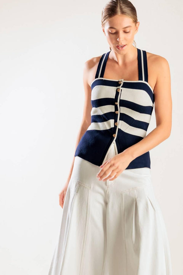 A navy and white striped sweater knit top featuring a halter neckline button down closure and cross back strap.