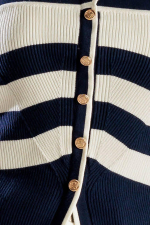 A navy and white striped sweater knit top featuring a halter neckline button down closure and cross back strap.