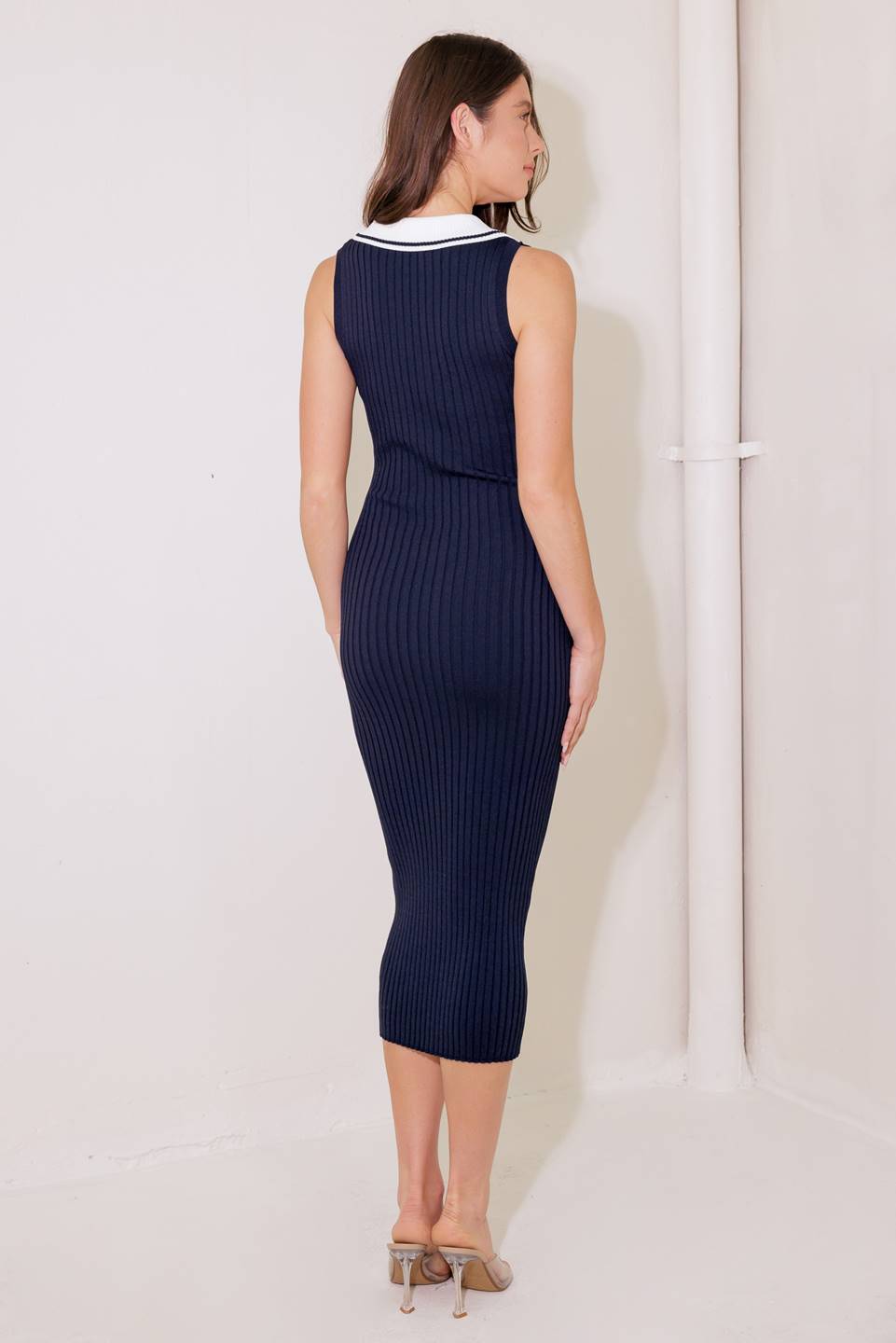 A navy ribbed sweater knit midi dress featuring collar, sleeveless and front button detail