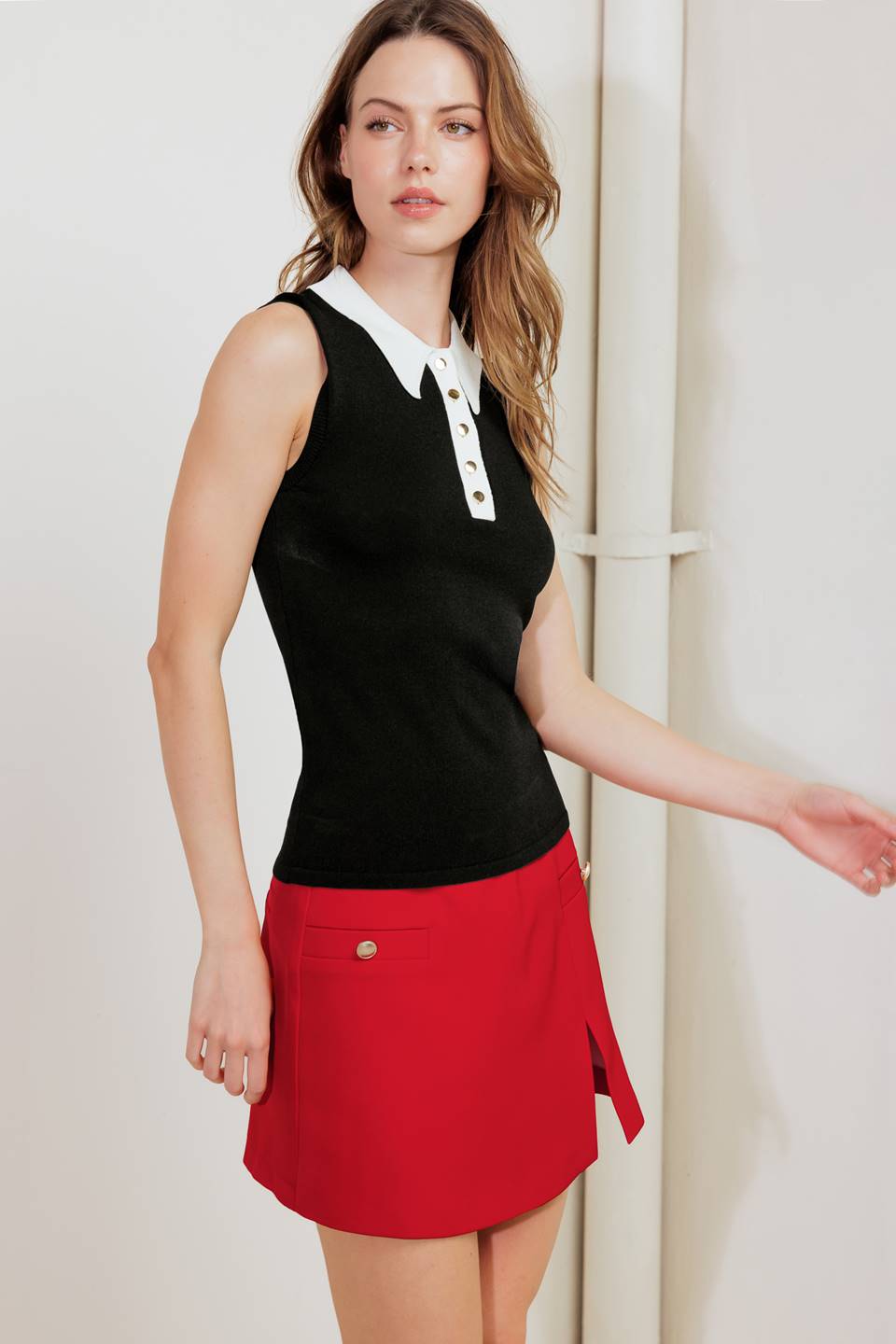 A sweater knit top featuring collar, front button down and sleeveless