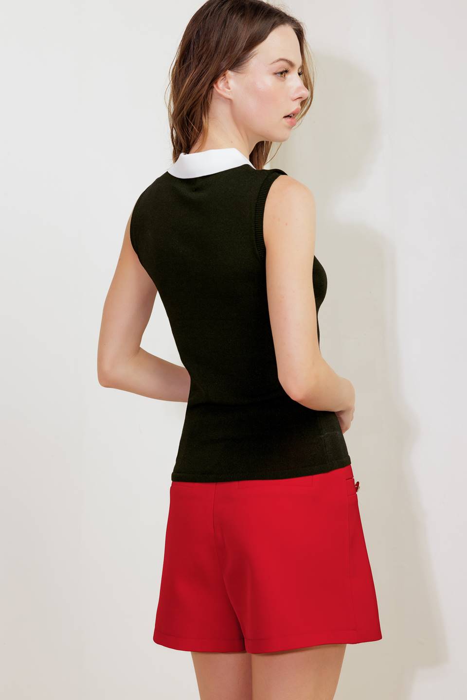 A sweater knit top featuring collar, front button down and sleeveless