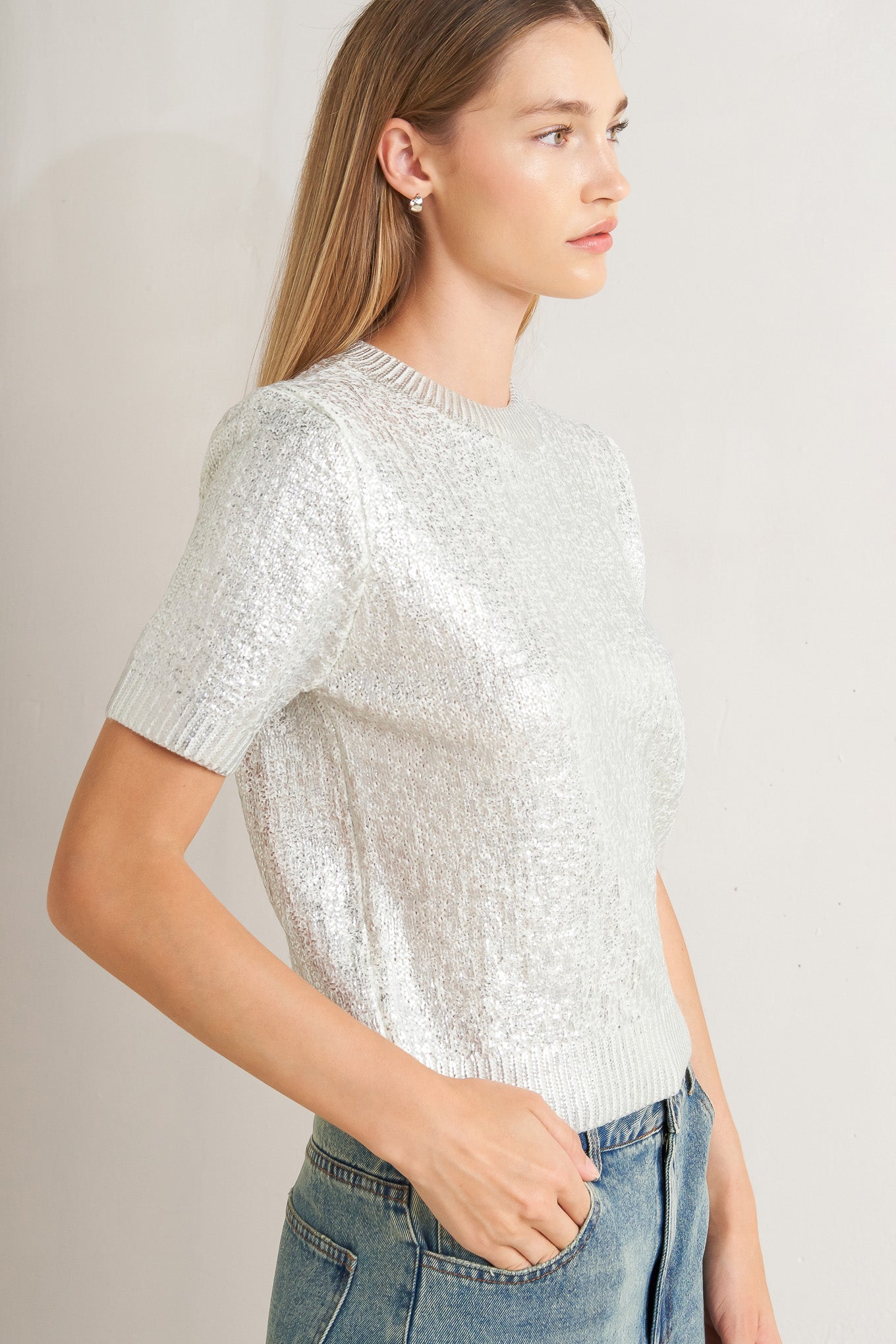 A foiled sweater knit top featuring crew neckline and short sleeve