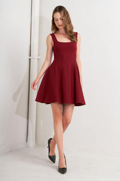 A solid sweater knit mini dress featuring square neckline, sleeveless and full skirt